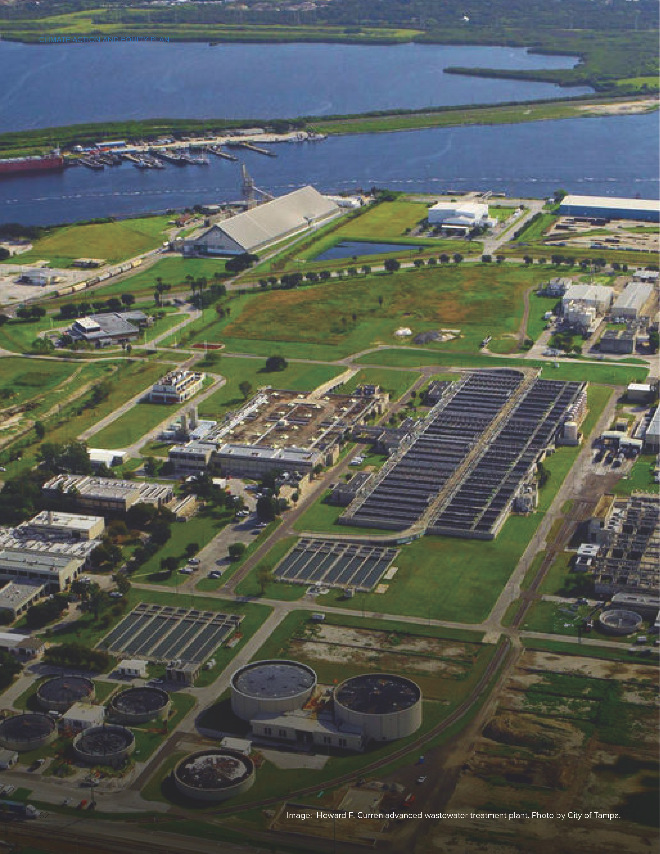 Aerial view of Howard F. Curren advanced wastewater treatment plant surrounded by green fields, water, and industrial structures.
