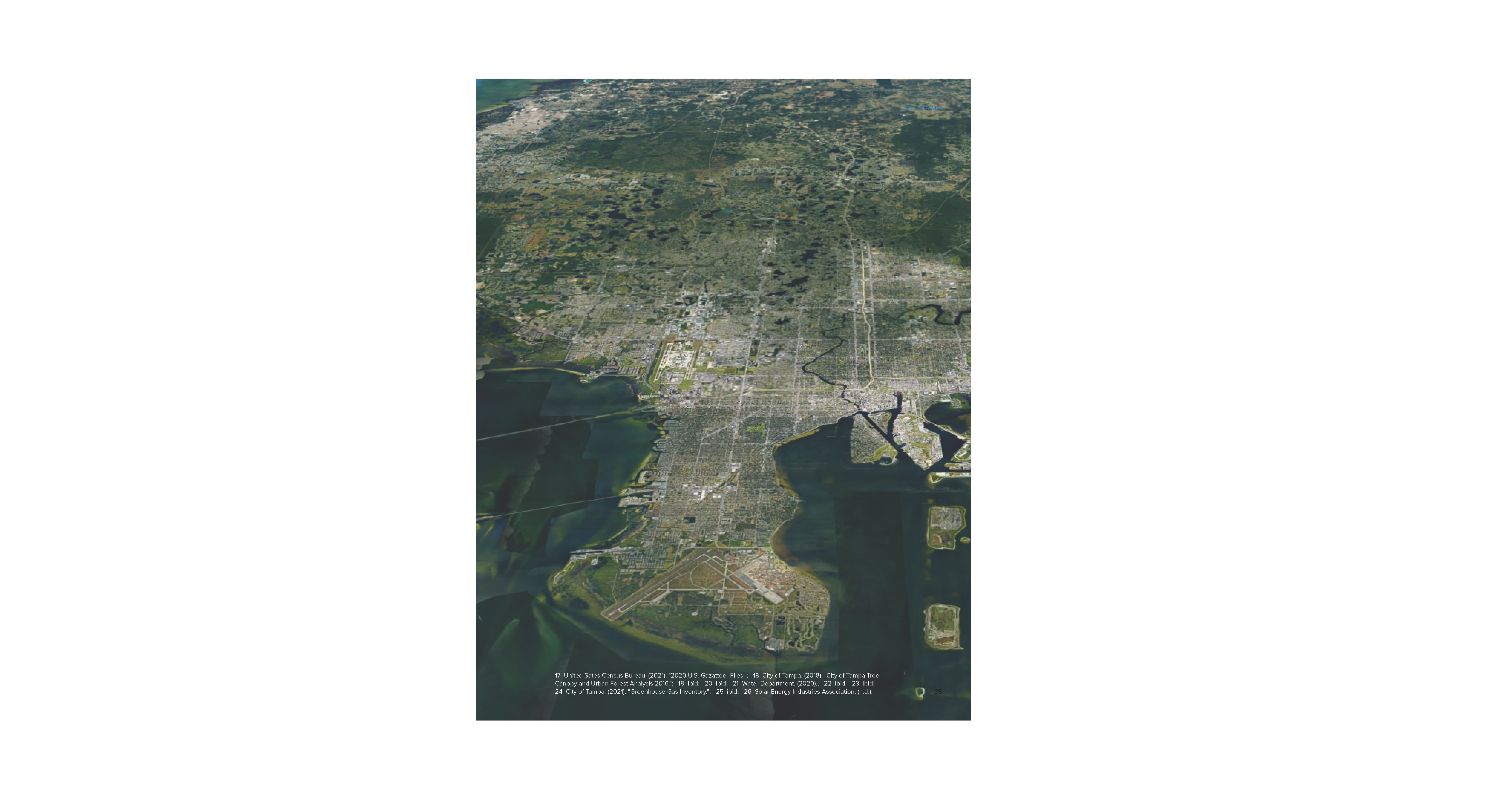 Aerial view of a city landscape featuring roads, buildings, and waterways, showcasing urban development and green spaces.