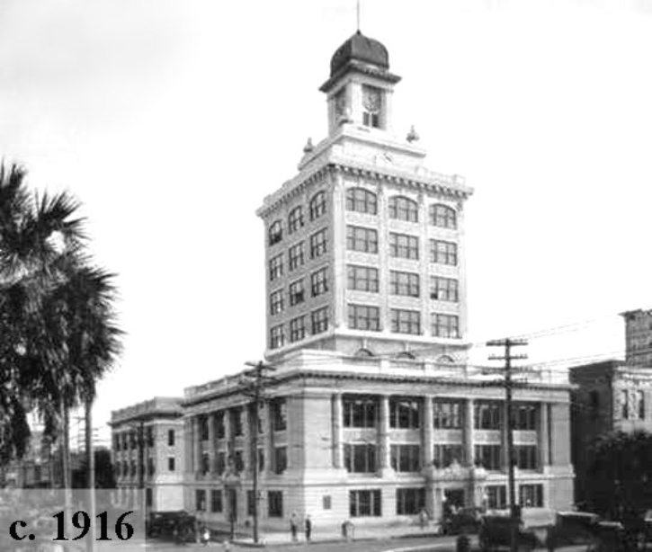 Historic black and white photo of a tall building with a dome, surrounded by palm trees, dated circa 1916.