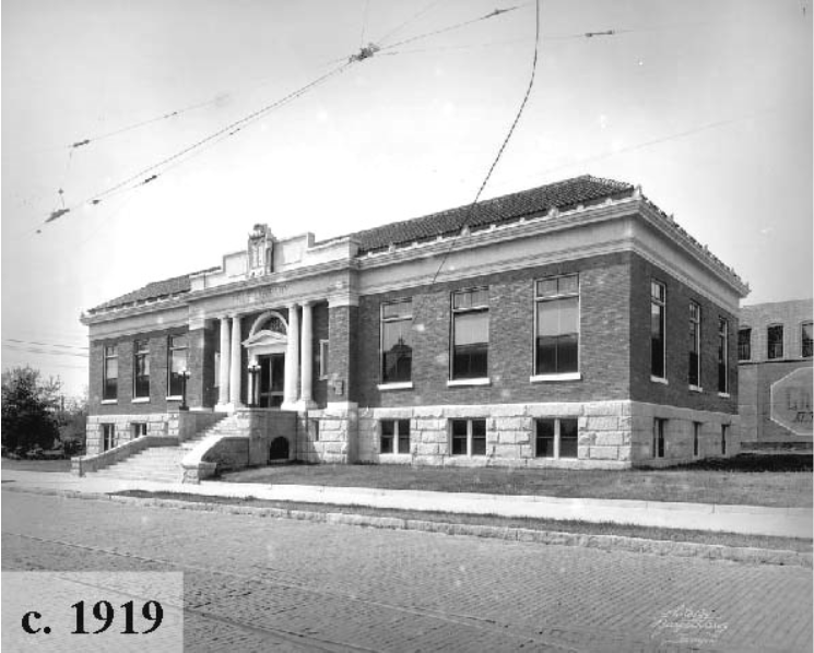 Historic black-and-white photograph of a brick building from 1919, featuring classical architectural details and steps leading to the entrance.
