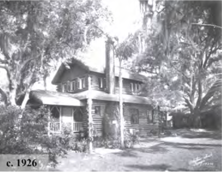 Historic black and white image of a log cabin-style house surrounded by trees, dated circa 1926.