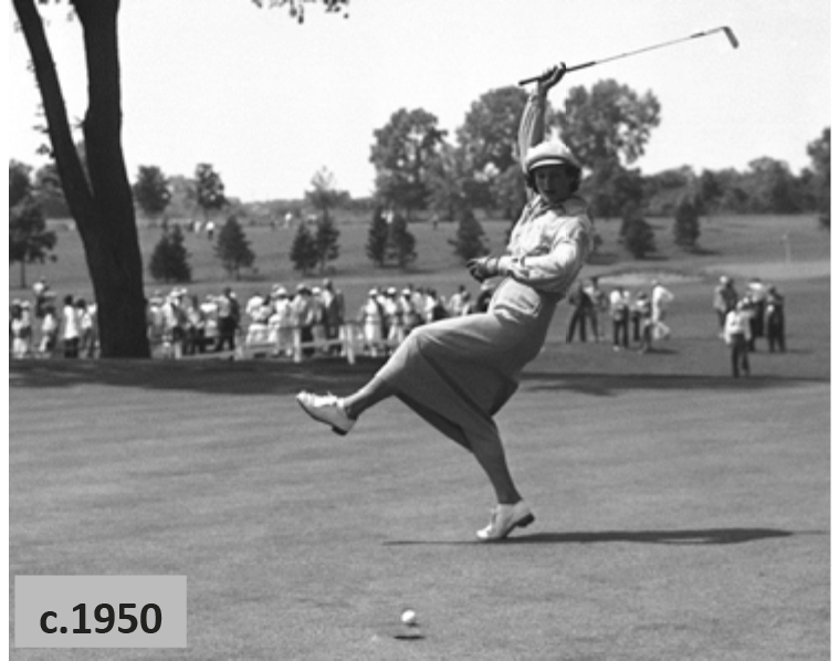 A woman in 1950s attire swings a golf club on a green, with a crowd in the background.