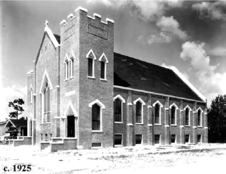 Historic black and white image of a brick church building, featuring gothic architectural elements, from around 1925.