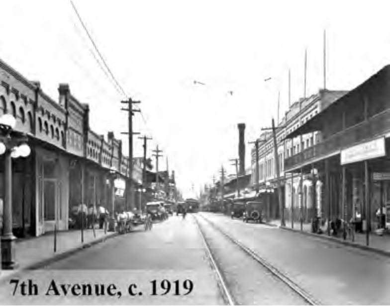 Historical black-and-white photo of 7th Avenue, circa 1919, showcasing buildings, streetcars, and people.
