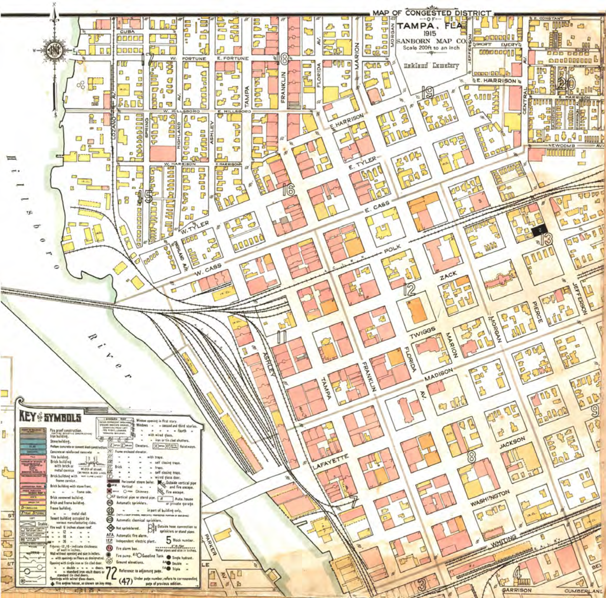 Historical map of Tampa with streets and buildings outlined, featuring a key for symbols and a river along the edge.