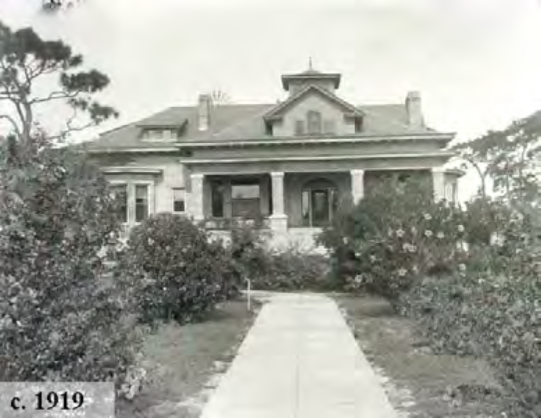 Historic house from circa 1919, featuring a landscaped path and surrounding garden.