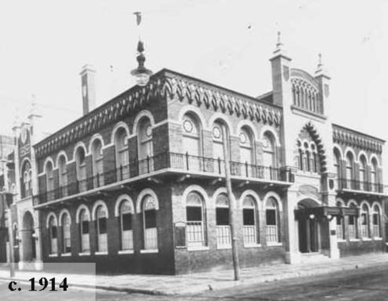 Historical black and white photo of a brick building with decorative architectural elements, taken around 1914.