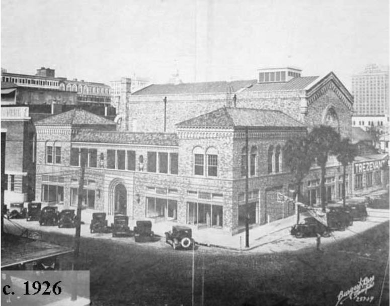 Historic black and white photo of a brick building, cars parked outside, taken circa 1926.
