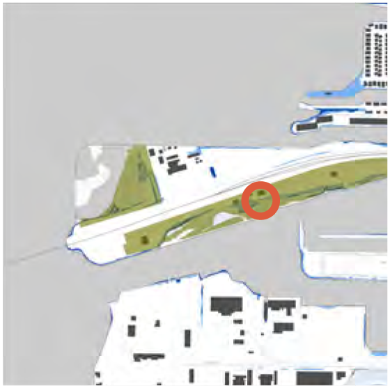 Map showing a highlighted area on a green strip of land near water, possibly indicating a park or recreational space.