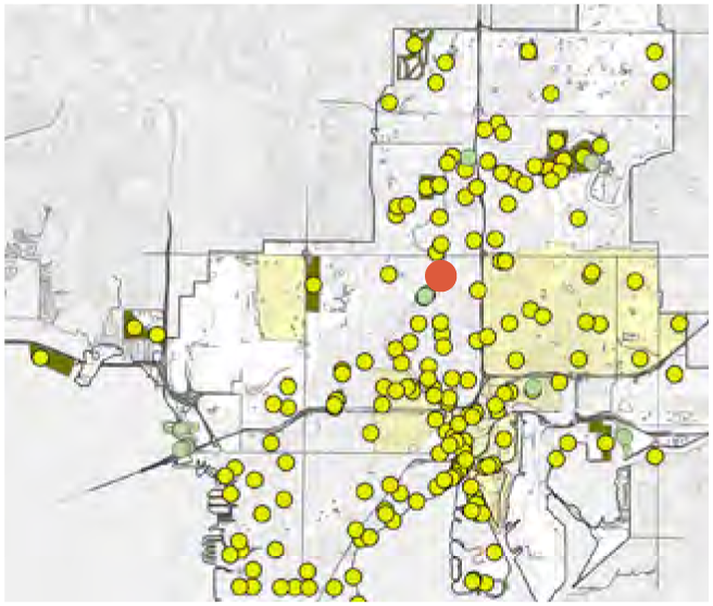 Map showing scattered yellow dots representing data points, with a highlighted red circle in the center, indicating a specific location.