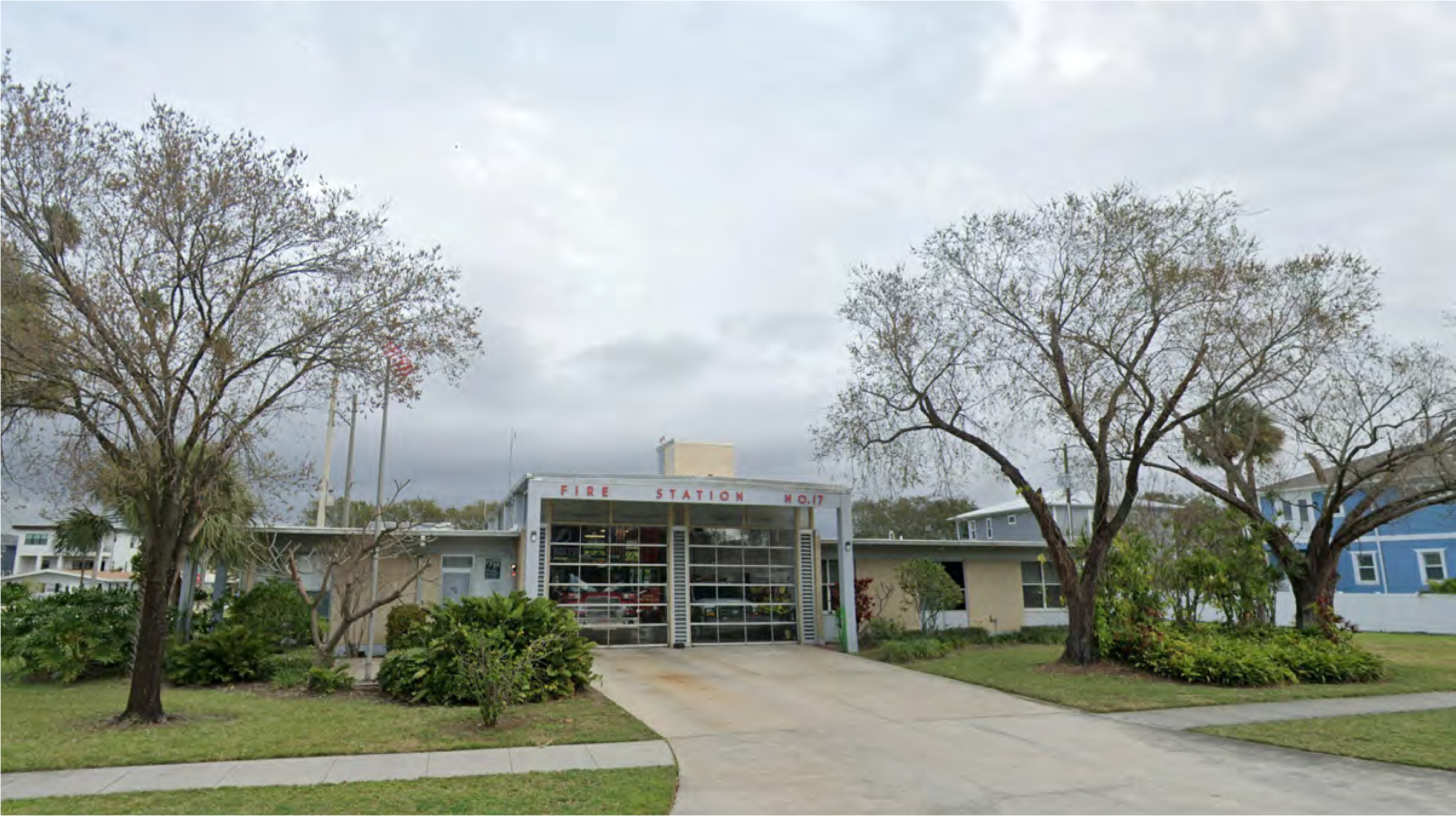 Exterior view of a fire station with gray skies, landscaping, and a prominent sign that reads 'FIRE STATION 60'.