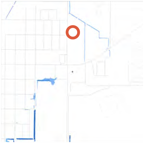 Map showing a highlighted location with a red circle, surrounded by grid lines and water features.