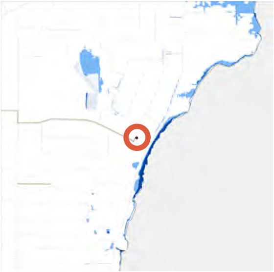 Map highlighting a specific location with a red circle, showing a coastal area with water bodies.