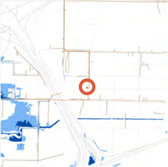 Map showing a highlighted location marked with a red circle, surrounded by blue water features and faint road outlines.
