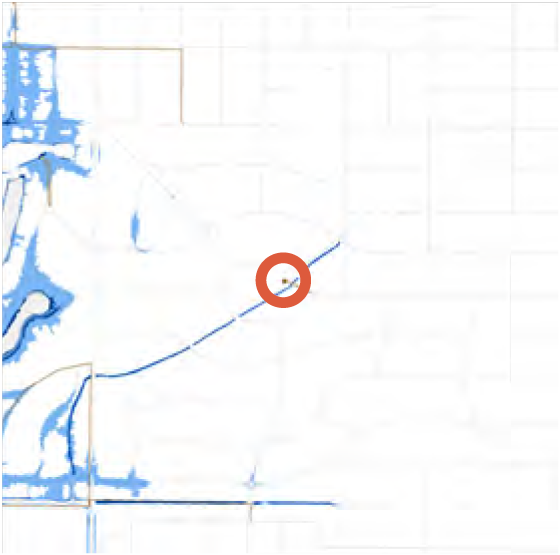 A map with a central location highlighted by an orange circle, surrounded by light blue and white areas.