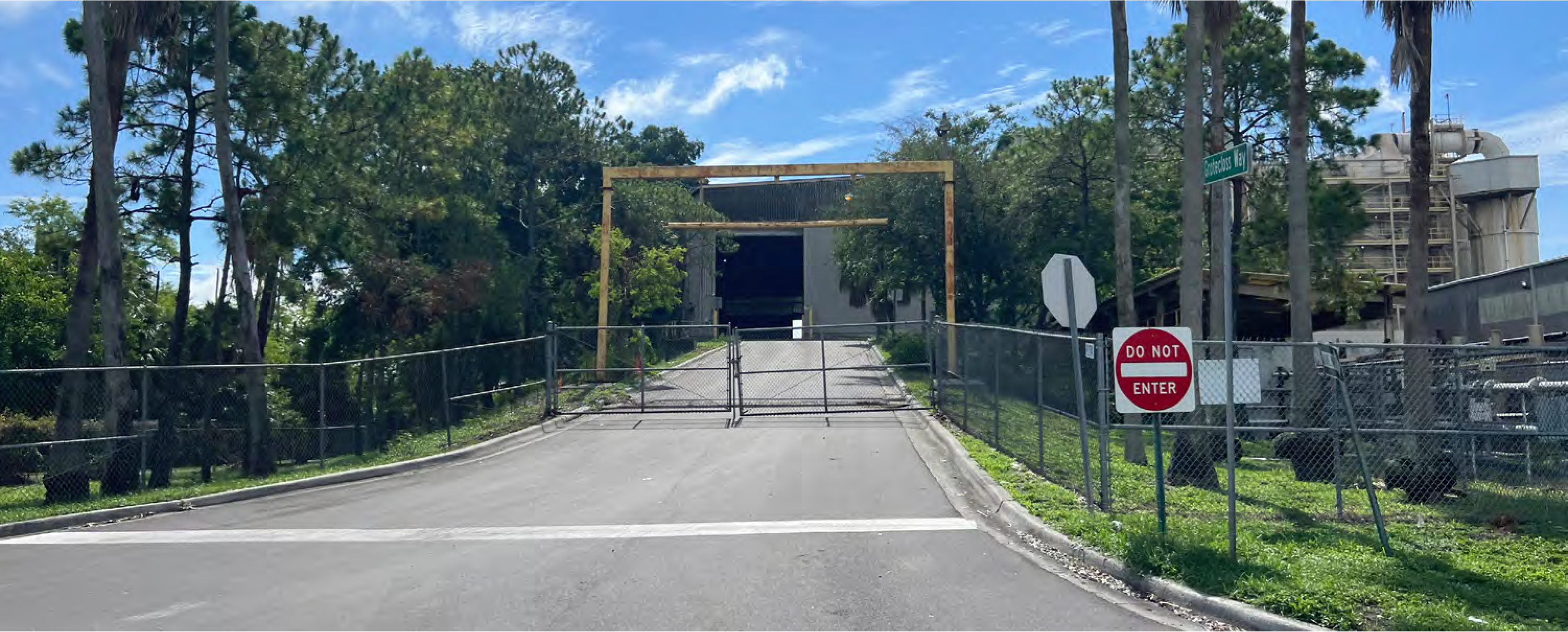 Closed access road leading to a facility, with a gated entrance and a 'Do Not Enter' sign.