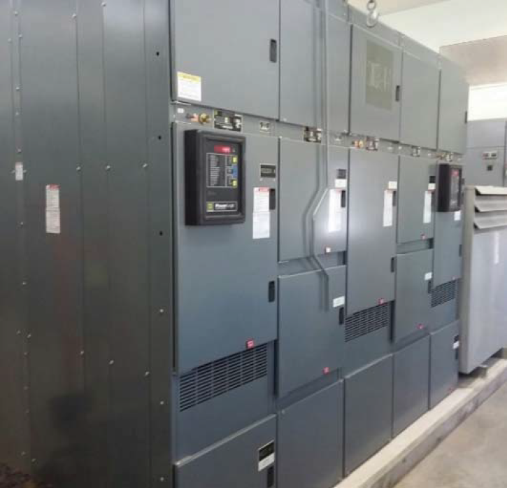 Gray electrical panels and equipment in a well-lit industrial setting.