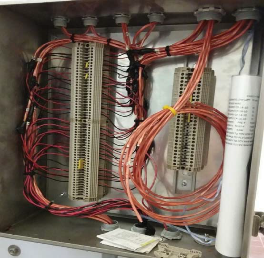 Internal view of an electrical cabinet with neatly arranged wires connected to terminal blocks.