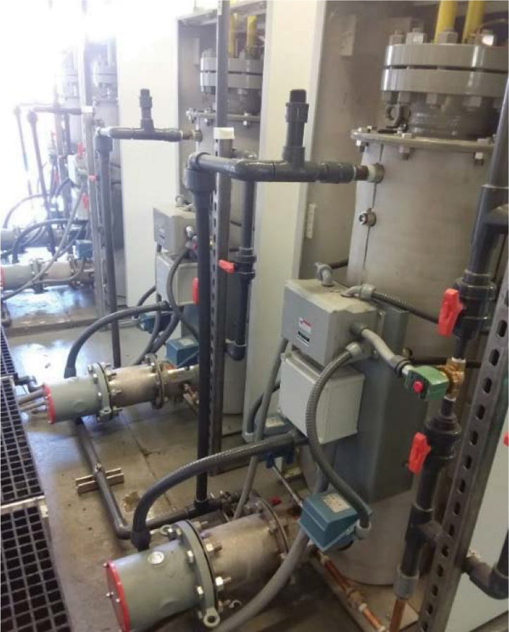 Industrial machinery featuring pipes, pumps, and control units, positioned in a technical facility.