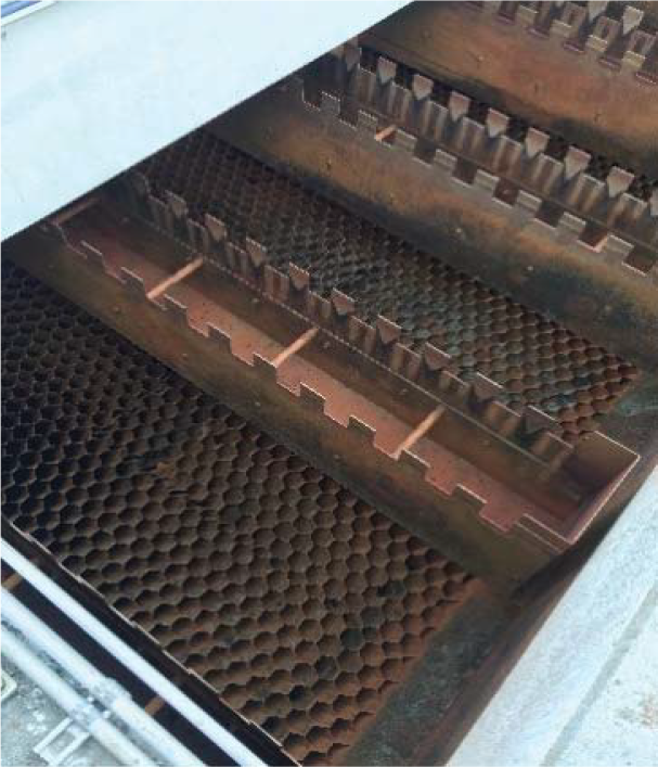 Close-up view of a textured metal surface with a hexagonal pattern and grooves, likely part of a mechanical or industrial component.