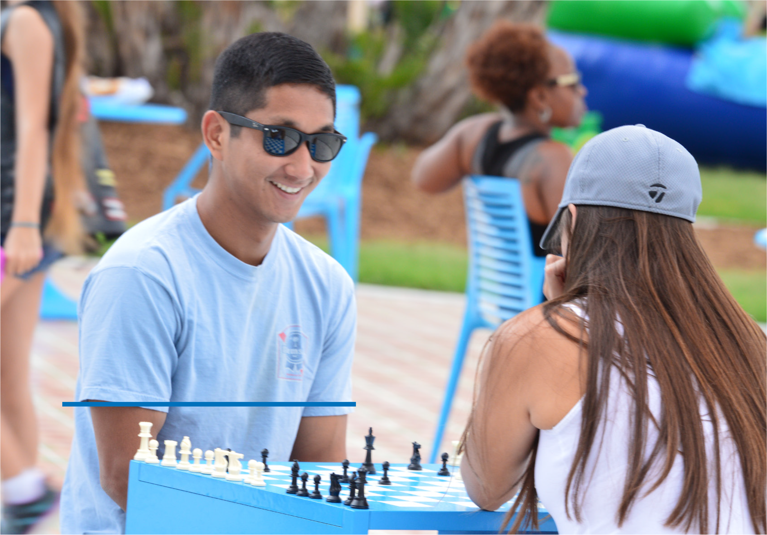 Two friends playing chess outdoors, smiling and engaged in the game, surrounded by a colorful environment.